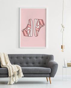 a living room with a gray couch and pink wall art on the wall above it