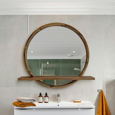 a bathroom with a sink, mirror and towel rack on the wall in front of it