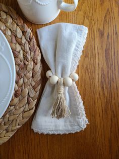 a napkin with tassels on it sitting next to a cup and saucer