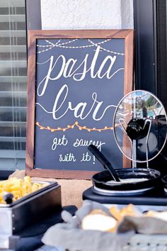 a sign that says pasta car next to some food on a table with other items