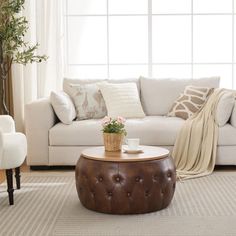 a living room filled with furniture and a white couch in front of a large window