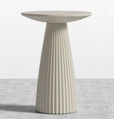 a white table sitting on top of a cement floor