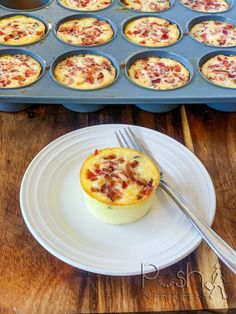 a muffin on a plate with a fork and cupcake tins in the background