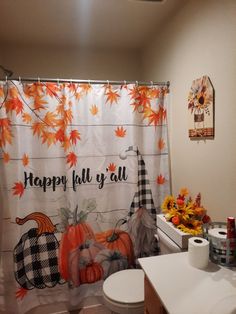 a bathroom decorated for fall with pumpkins and gingham decorations on the shower curtain