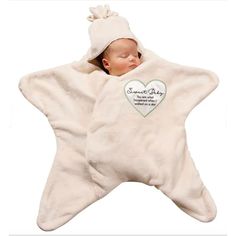 a baby sleeping in a white star shaped blanket