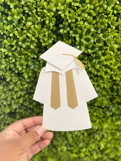 someone is holding up a paper cutout of a graduate's cap and gown