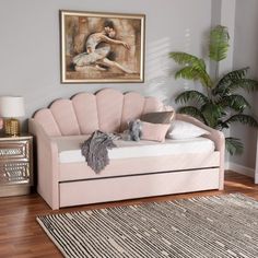 a pink daybed with pillows and stuffed animals on it next to a potted plant