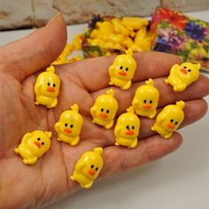 small yellow rubber chicks sitting in the palm of someone's hand next to other toys