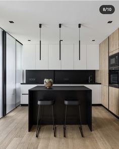 a black and white kitchen with two stools