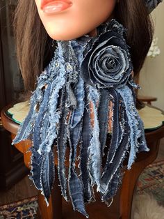 a mannequin head wearing a scarf made out of old jeans and denim flowers