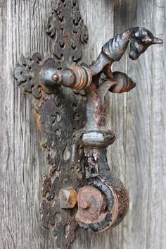 an old rusty door handle on the side of a wooden building