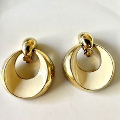 These clip on vintage earrings are so chic and glamorous! Italian style, gold and white (a very elegant off white) circular shape, large earrings that you would expect to see in an Italian vintage fashion magazine, circa 1950's-1960's or a mid century Hollywood movie. They're fabulous- fun and elegant! Height 2 1/4" Width 2" Gold Seventies Inspired Jewelry, White Vintage Earrings, White Vintage Round Earrings, Vintage White Round Clip-on Earrings, Italian Vintage Fashion, Vintage Italian Style, 1970s Earrings, 1960s Earrings, 60s Earrings