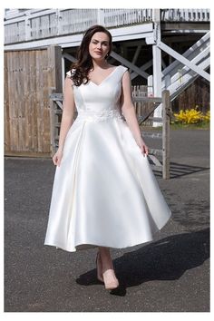 a woman in a white dress posing for the camera