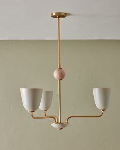 three light fixture hanging from the ceiling in a room with beige walls and flooring