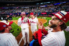 some baseball players are standing in the middle of a field and one is holding a trophy