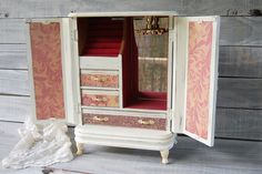 an old dresser has been painted pink and gold with red velvet on the top drawers