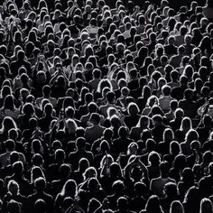 a large group of people standing together in the dark, with their backs turned to the camera