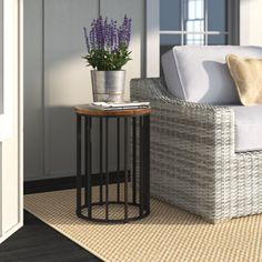 a wicker chair and table in front of an open door with purple flowers on it