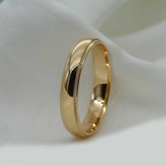 a gold wedding ring on top of a white cloth