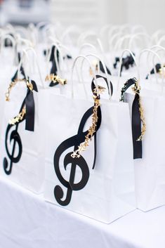 white bags with black and gold musical notes on them are lined up on a table