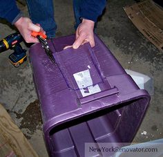 a person is cutting into a purple suitcase