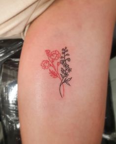 a small flower tattoo on the right arm and shoulder, with red flowers in it