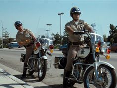 two police officers riding motorcycles on the street