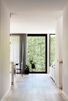 an empty hallway leading to a bedroom with sliding glass doors that open up into the outdoors