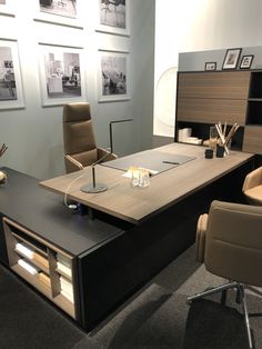 an office desk with chairs and pictures on the wall