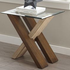 a glass and wood table with a star decoration on top, next to a window