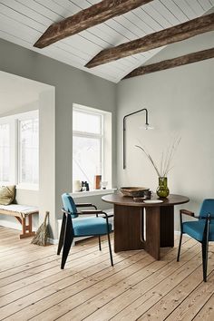 a dining room with wooden floors and blue chairs