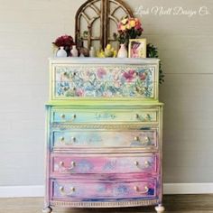 an old dresser has been painted with colorful paint and flowers on the top, along with other items