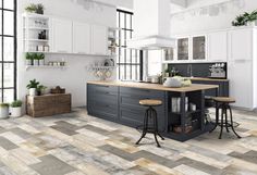 a large kitchen with two stools in front of the island