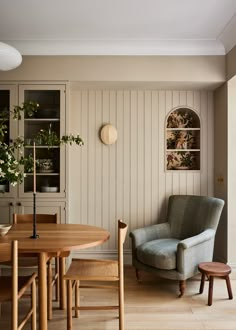 a living room filled with furniture and a wooden table next to a wall mounted clock