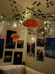 some lights hanging from the ceiling in a room with pictures on the wall and ivy growing over it