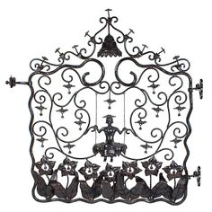 an iron gate with birds on it and crosses above the top, in black and white