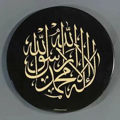 an arabic calligraphy on a black plate with gold writing in the middle and bottom