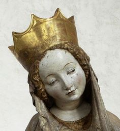 a statue with a crown on top of it's head, wearing a dress