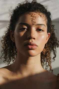 Portrait en lumière naturelle d'une jeune femme à la peau dorée et aux cheveux bouclés, regard direct et expressif, portant une boucle d'oreille Chanel, avec un jeu d'ombres et de lumières sur le visage Face Inspiration Woman, Face On Portrait, Head Portrait Photography, Unique Faces Photography Portraits, Unique Portrait Reference, Unique Beauty Women, Hairstyles Men Curly Hair, 2 People Portrait, Unique Faces Photography