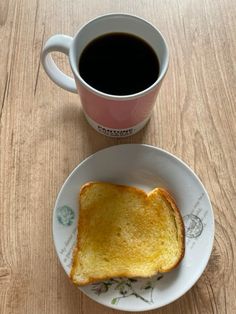 a sandwich on a plate next to a cup of coffee