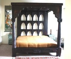 a bed sitting in the middle of a room next to a rug on the floor