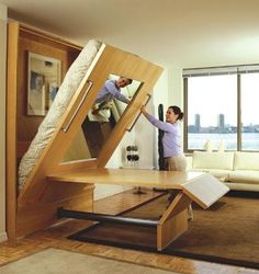 a woman standing next to a bed in a living room under a loft style bed