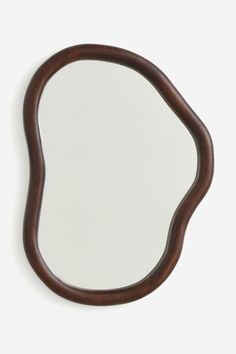 an oval wooden mirror on a white wall with a brown frame and dark wood handle