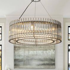 a large chandelier hanging from the ceiling in a dining room with white walls and windows