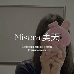 a woman holding a pink stuffed animal in front of her face with the caption misora