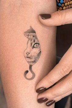 a woman's arm with a cat tattoo on the left side of her body