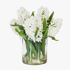 a glass vase filled with white flowers on top of a table