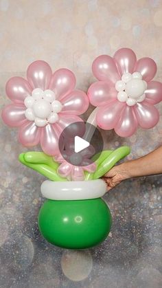 a vase filled with pink and white flowers sitting on top of a green ballon