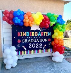 a sign with balloons on it that says kindergarten graduation