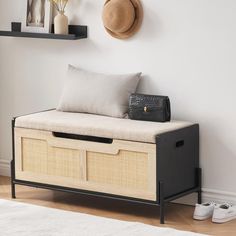 a black and white bench with two baskets on it next to a wall mounted hat rack